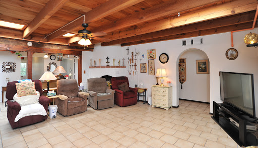 A cozy living room featuring comfortable recliners, a wooden ceiling, and tasteful decorations.