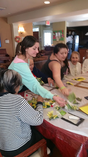 Participants engage in a floral arrangement workshop, fostering creativity and connection within the community.