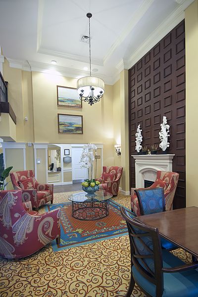 A spacious living room with high ceilings, elegant furniture, and a sophisticated fireplace provides a cozy and stylish atmosphere.