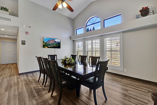 A spacious and modern dining room featuring a large table, comfortable chairs, and elegant windows that let in natural light.