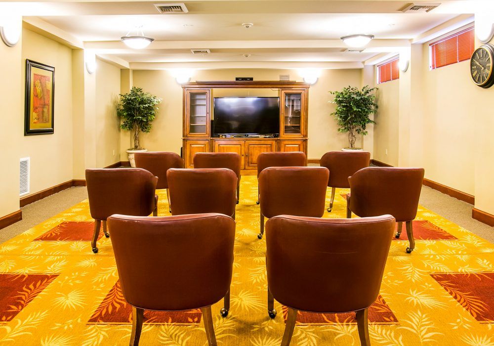 A small conference room with rows of chairs facing a television.