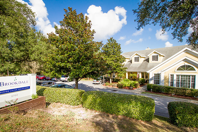 A charming house with well-maintained landscaping under a clear blue sky.