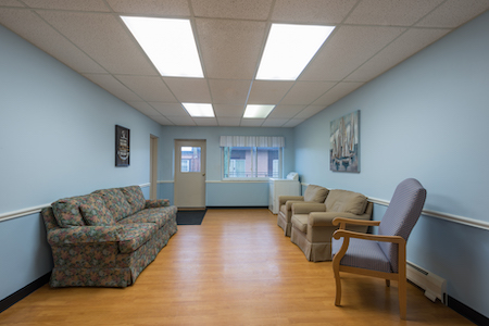 A cozy waiting room featuring comfortable seating and ample natural light.