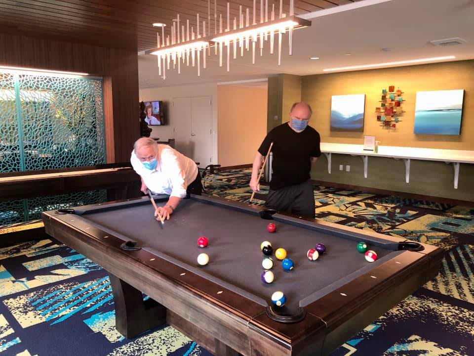 Two people enjoying a game of billiards in an indoor setting.