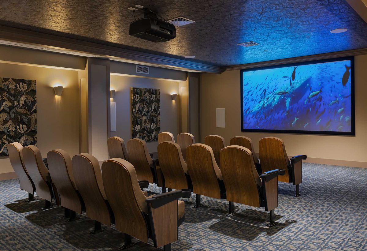 A cozy home theater setup with multiple rows of seating and a large screen.