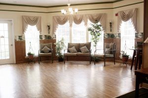 A spacious living area with elegant decor, featuring large windows, soft curtains, and comfortable seating.