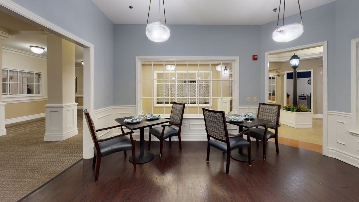 A modern dining area with neatly arranged tables and chairs, featuring stylish lighting.