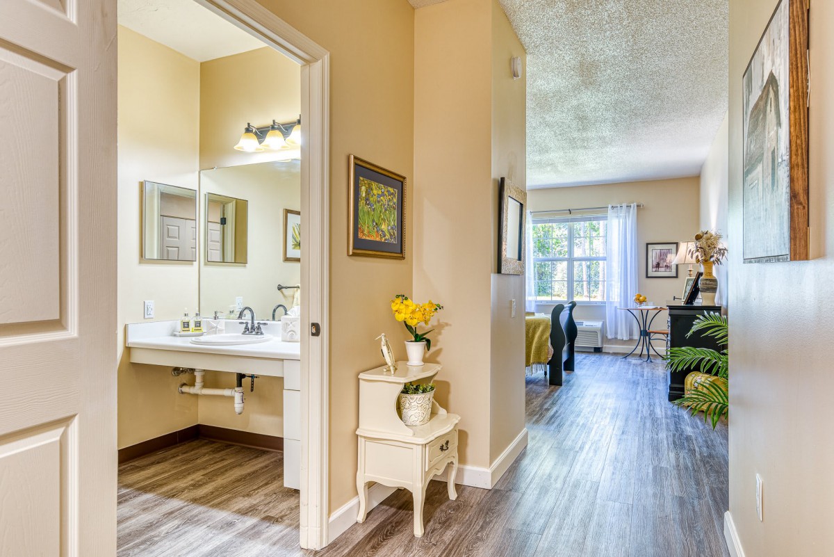 A cozy interior showcasing a bathroom and living room with soft lighting and elegant decor.