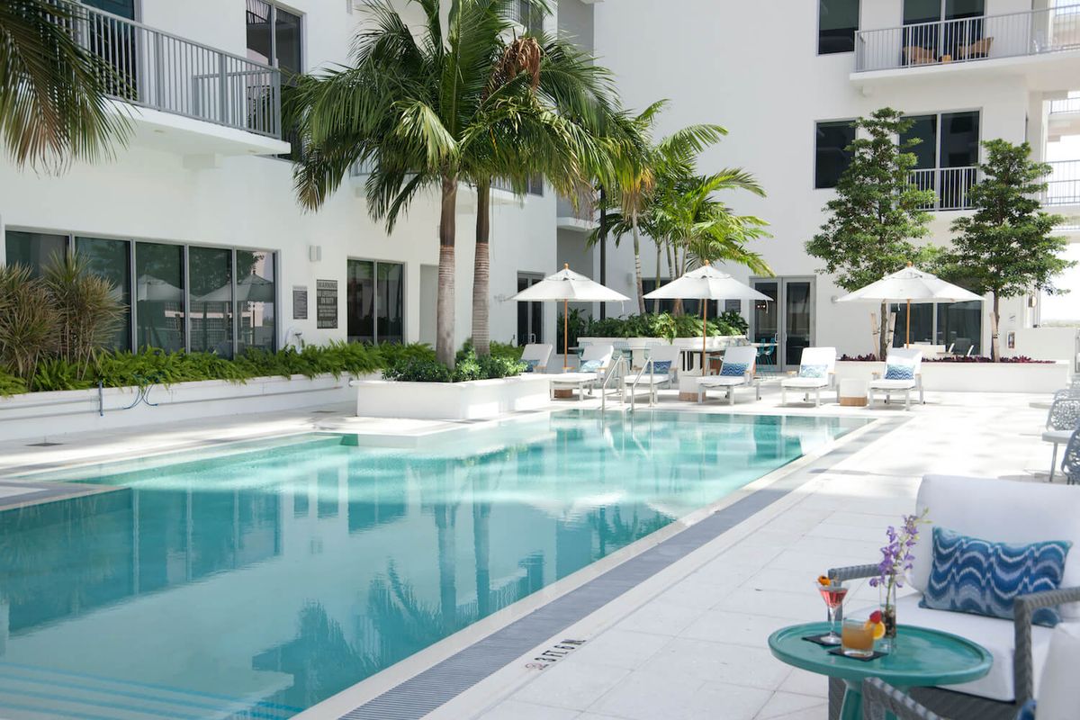 A luxurious outdoor swimming pool area surrounded by palm trees, perfect for a tropical vacation.