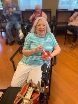 A senior woman enjoying ice cream at a social gathering indoors.