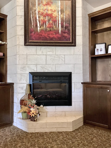 A beautifully decorated living room featuring a modern fireplace, surrounded by elegant shelving and autumn-themed accents.