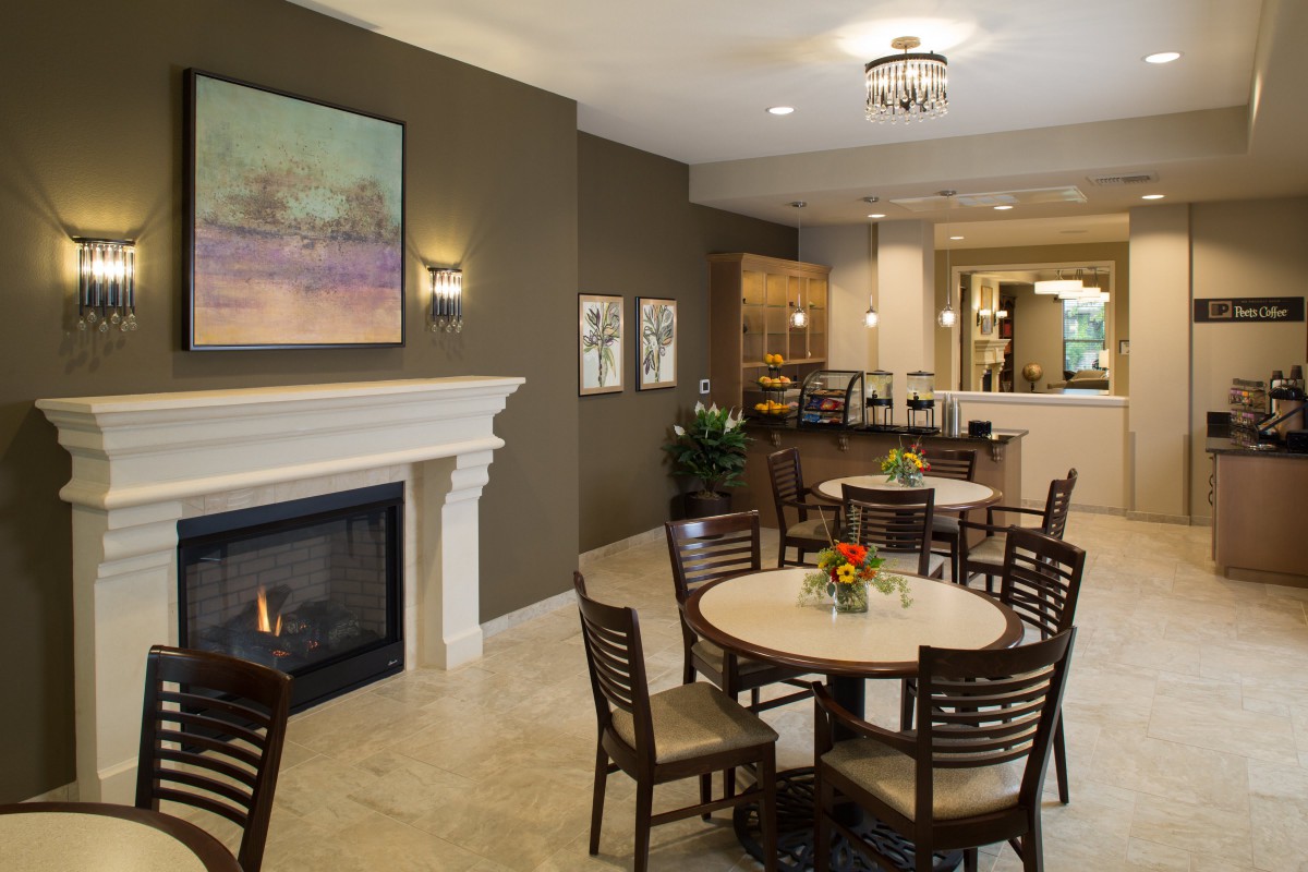 Cozy and elegant dining area with a fireplace, decorated with flowers and artwork.