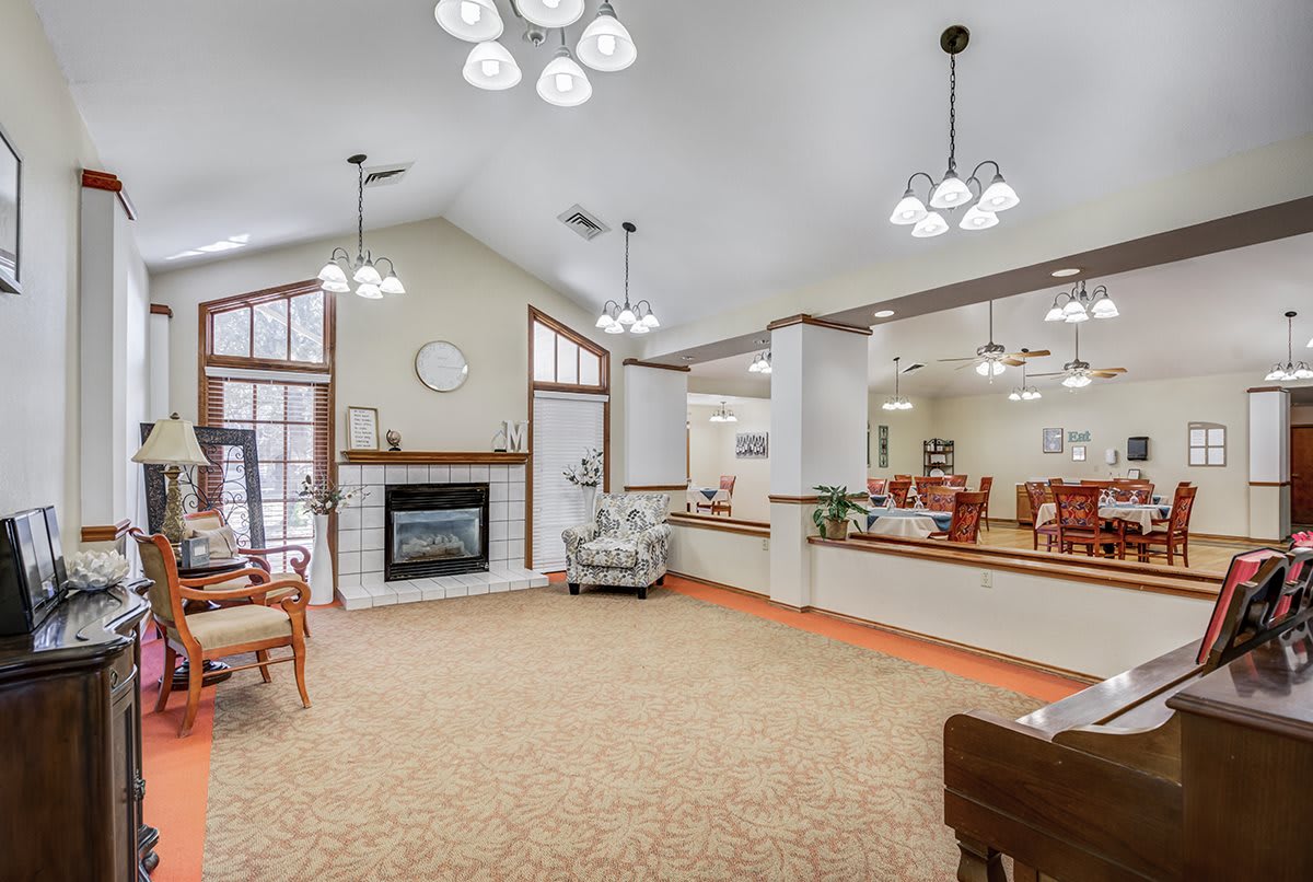 A spacious and cozy living room with elegant lighting and a fireplace.