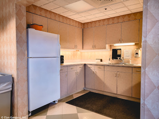 A tidy kitchen corner featuring a refrigerator, countertop, and cabinets.