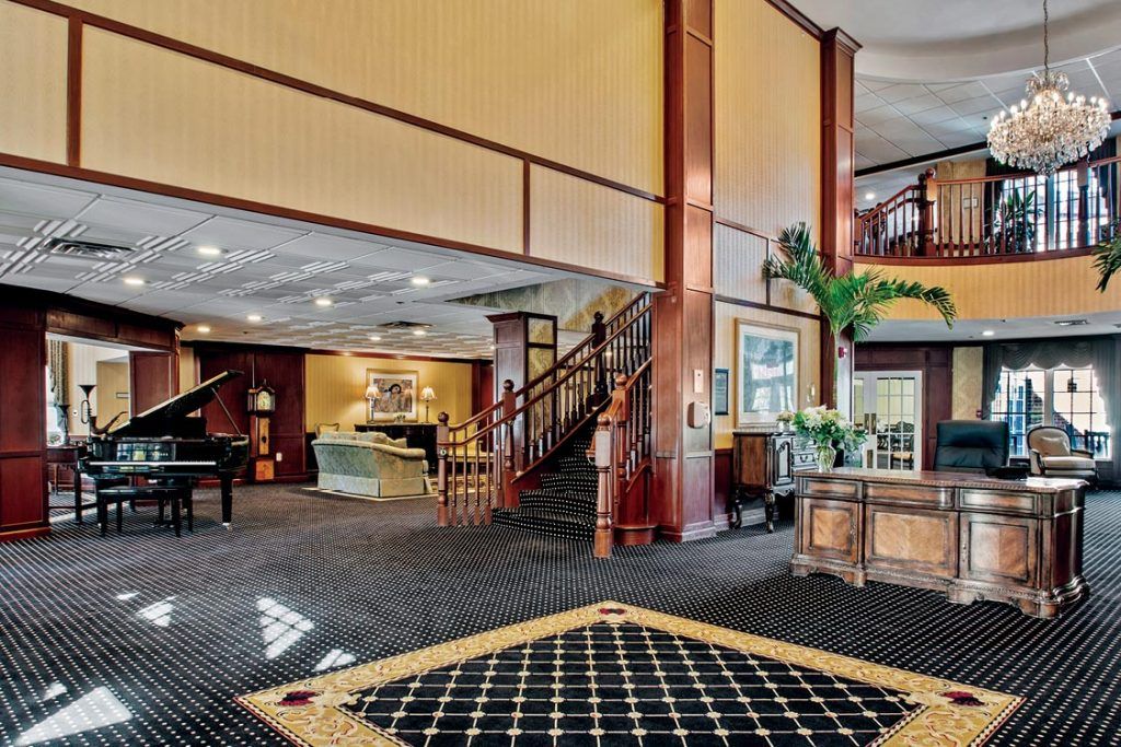 A spacious hotel lobby with a staircase and comfortable seating.