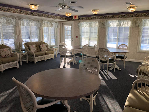 A cozy lounge area featuring comfortable seating and tables, illuminated by natural sunlight.