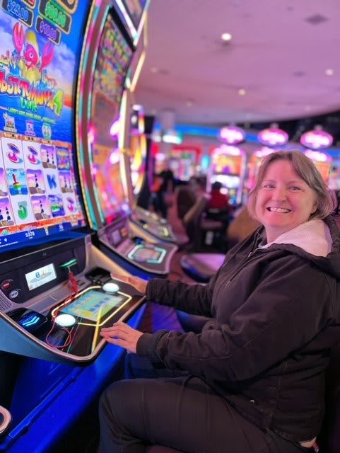 A woman enjoying her time playing slot machines in a casino.