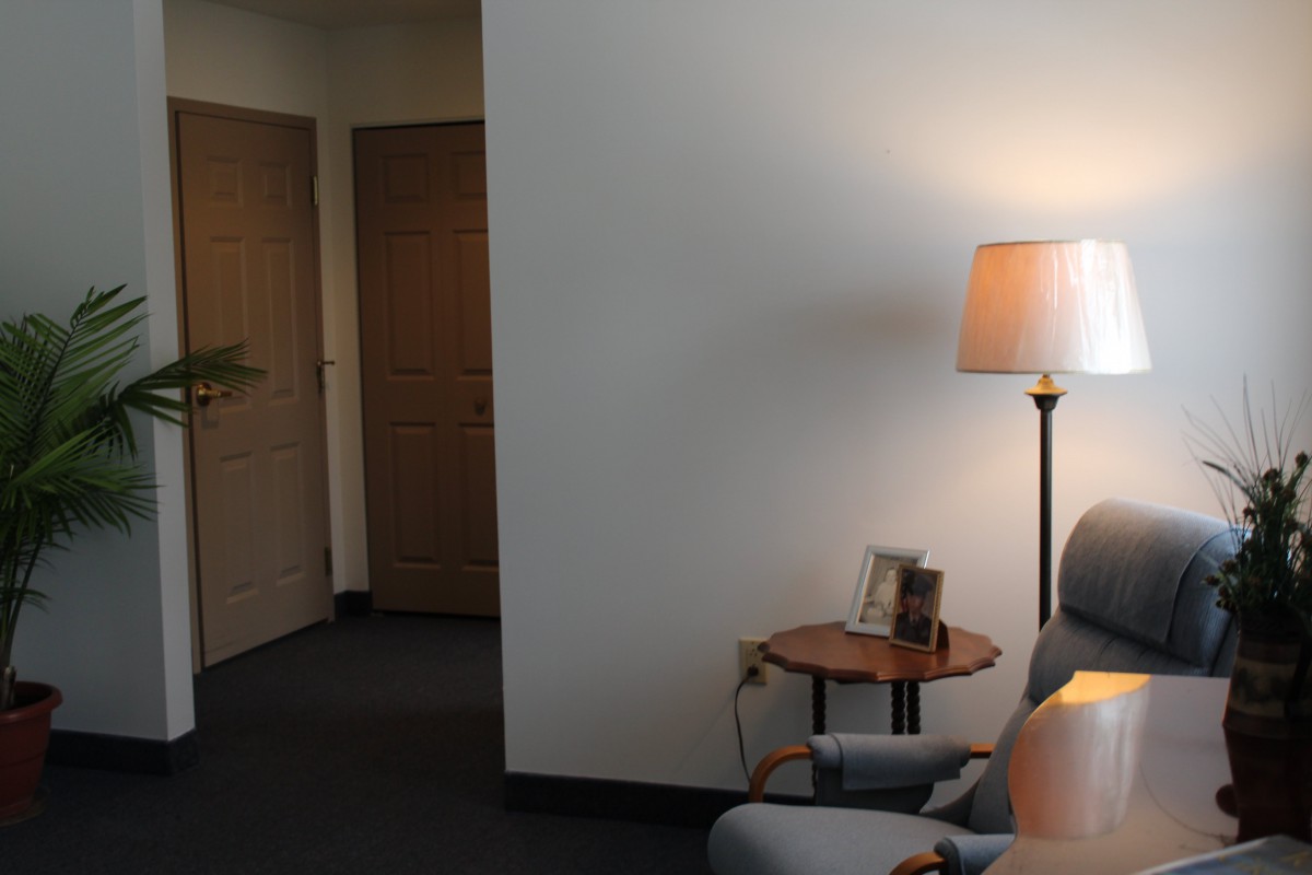 A cozy corner with a lamp and chair in a living room setting.