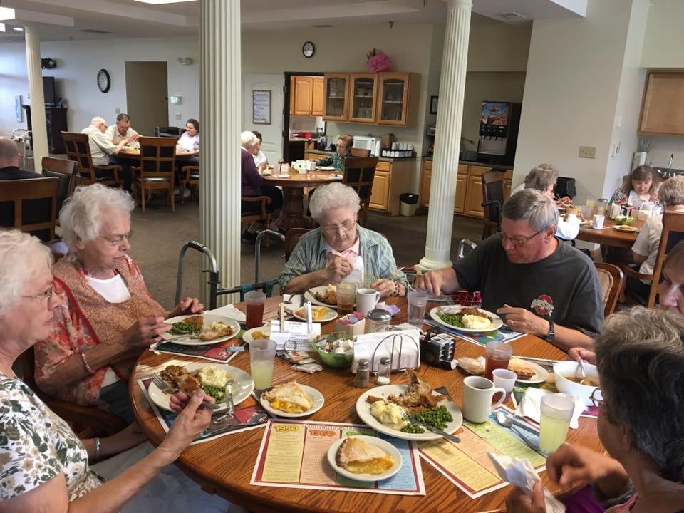 A group of elderly people enjoying a meal together in a community setting.