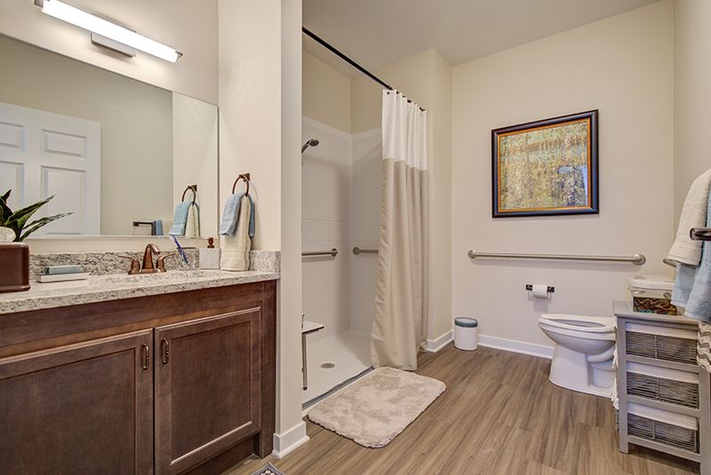 A modern bathroom with a shower, toilet, and sink area.