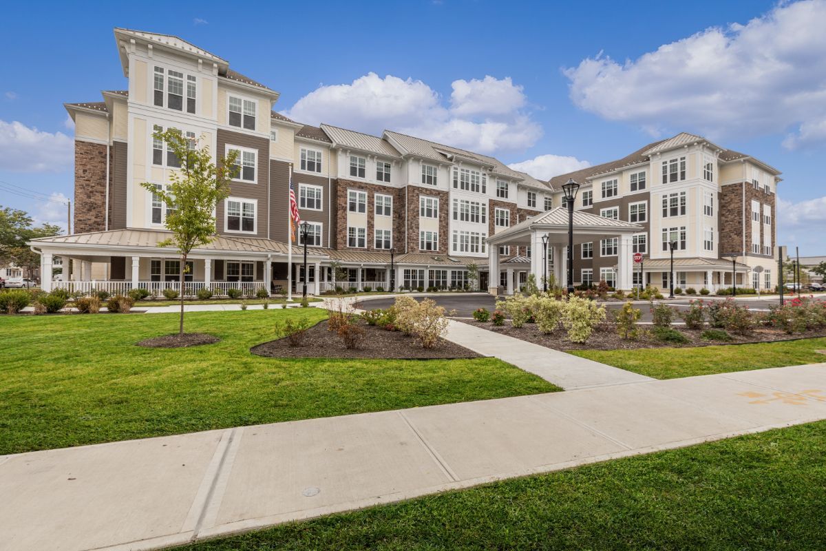 A modern residential building with well-maintained landscaping and a walkway in the foreground.