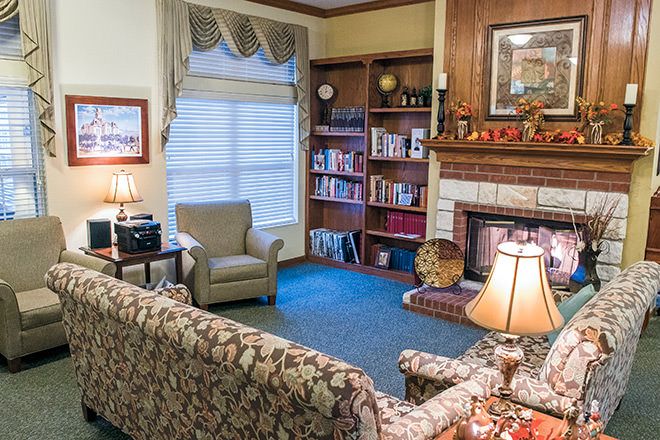 A cozy living room with a fireplace, bookshelves, and comfortable seating.