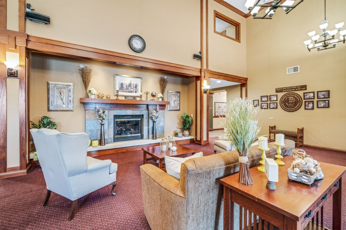 A cozy living room featuring a central fireplace, comfortable seating, and warm decor.