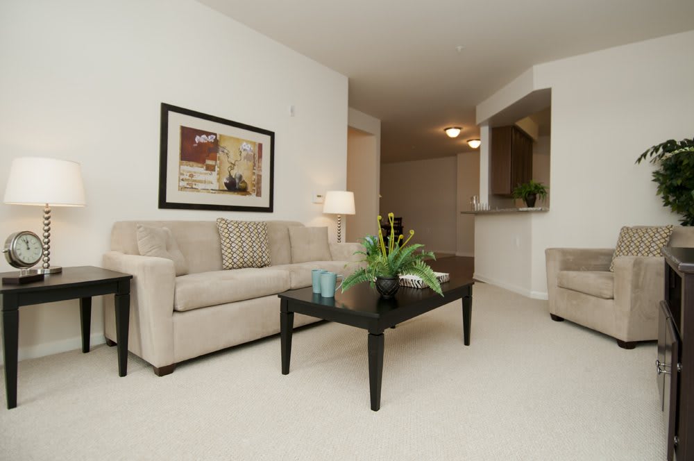 A minimalist living room featuring a comfortable sofa, a coffee table with decor, and wall art.