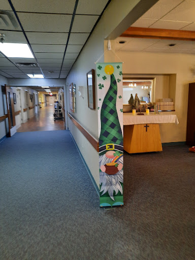 A festive decoration featuring a green Christmas tree and a snowman in a hallway.