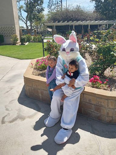 A playful moment captured with the Easter Bunny and two excited children at a spring celebration.