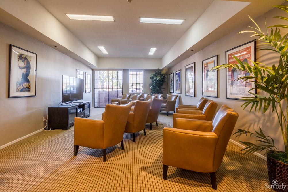 A modern lounge area with comfortable chairs and a television, perfect for relaxing or waiting.