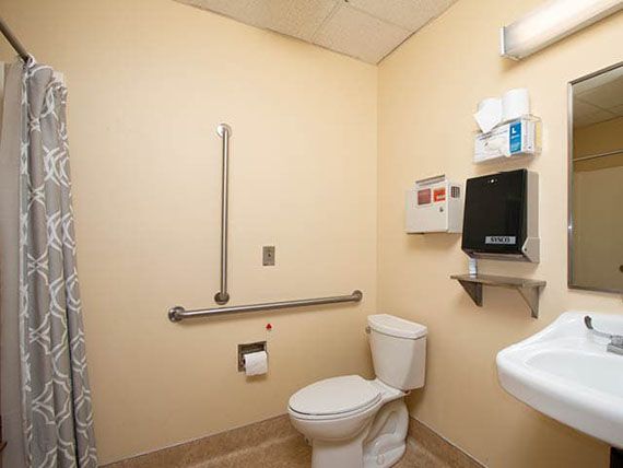 An accessible bathroom with handrails and a clean, minimalistic design.