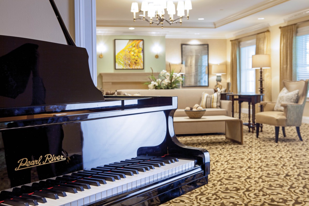 A luxurious living room featuring a grand piano and elegant decor.