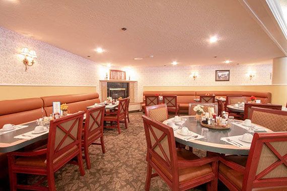 An empty restaurant dining area with neatly arranged tables and chairs.