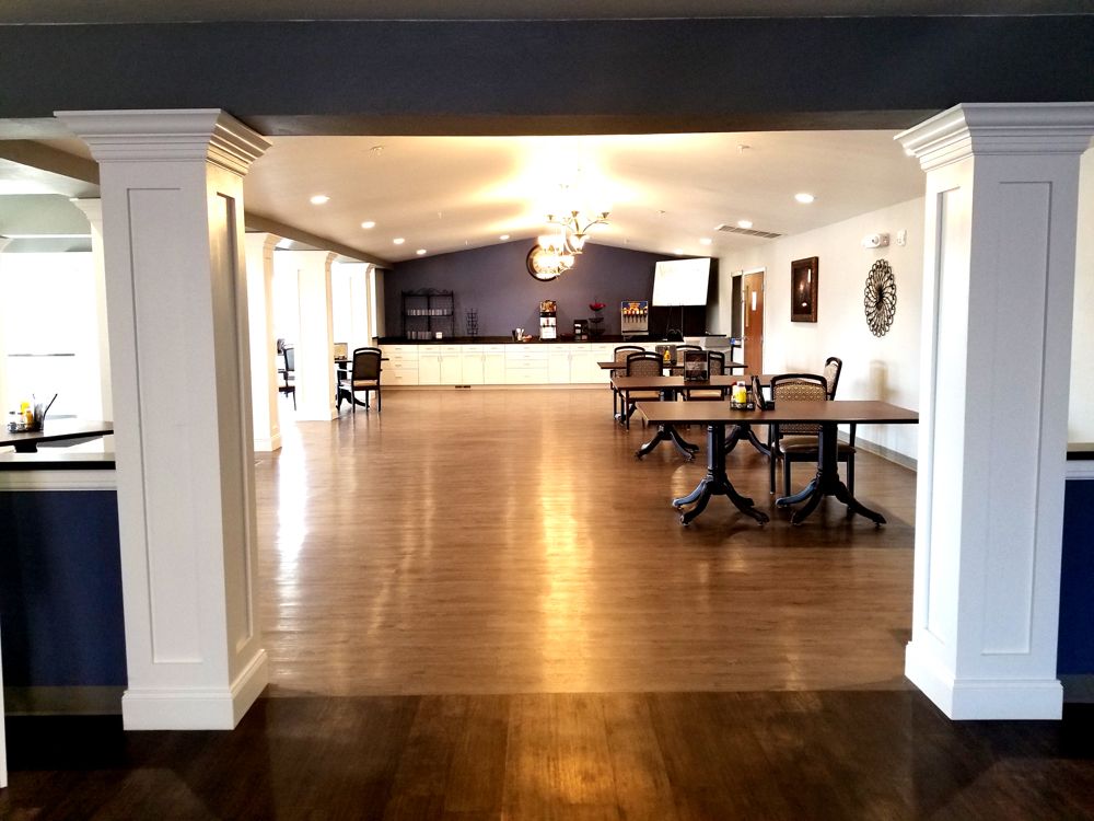 An elegant dining hall with wooden floors and a chandelier.