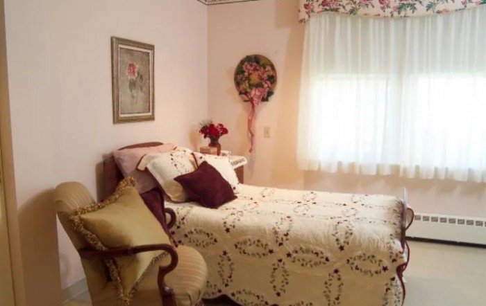 A cozy vintage-style bedroom with a neatly made bed and decorative accents.