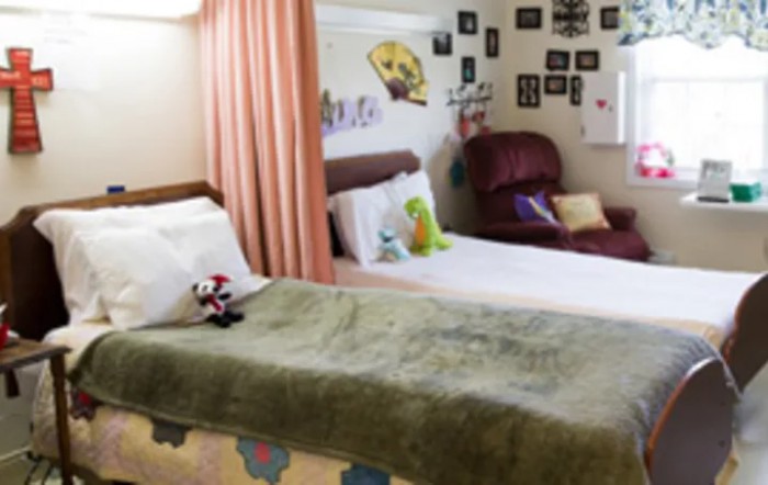 A cozy bedroom with a comfortable bed, pillows, and colorful decor.