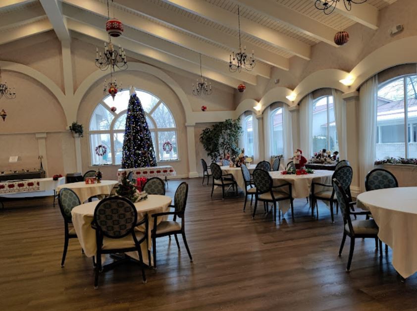 A festive dining area adorned with Christmas decorations and a large tree.