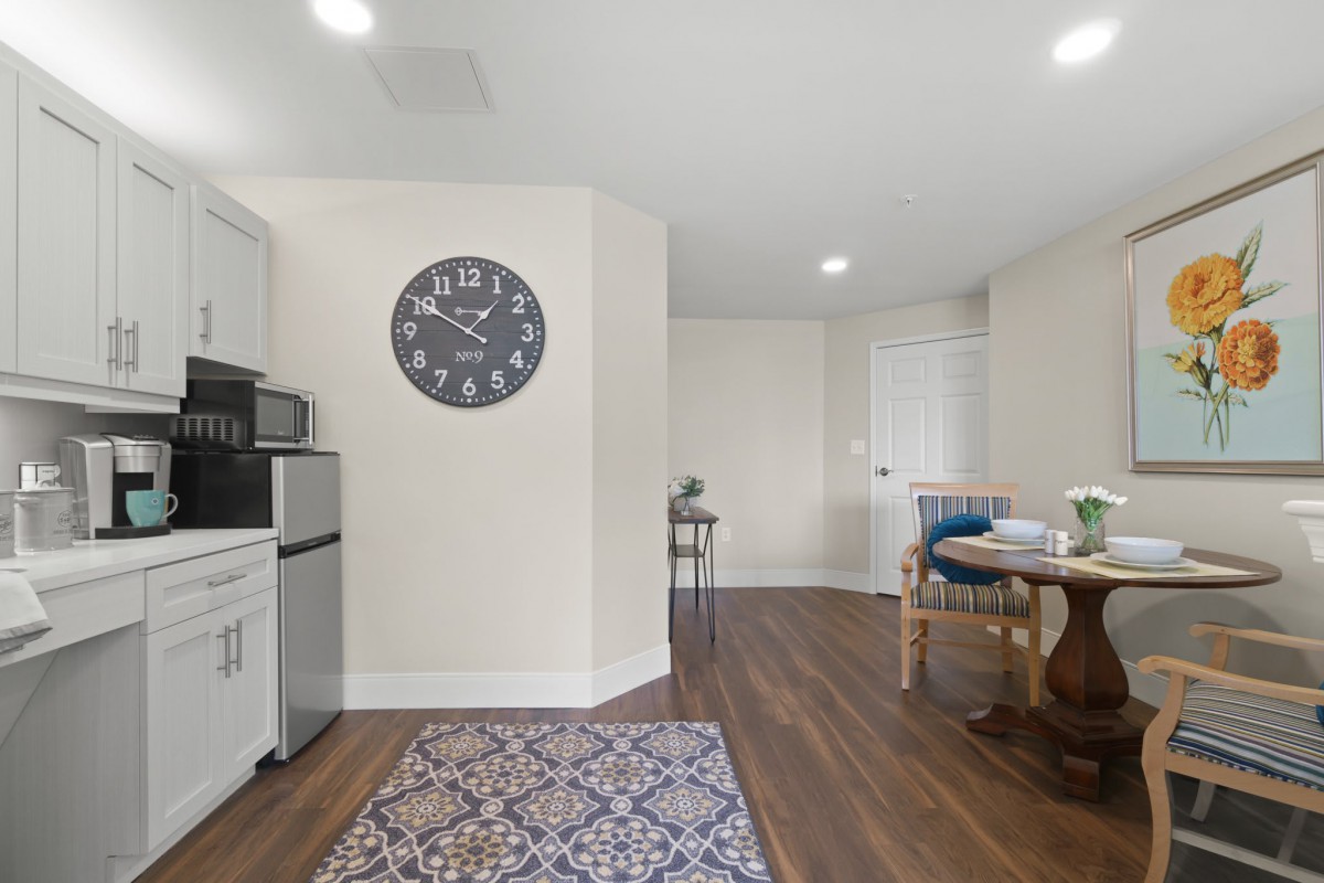 A cozy kitchenette with a mini fridge, microwave, and modern decor accents.