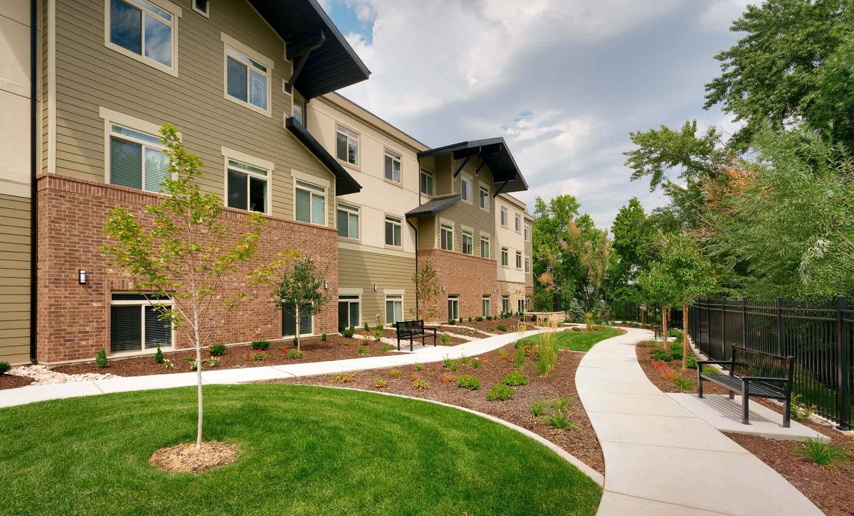 A well-maintained apartment building with a landscaped path and greenery.