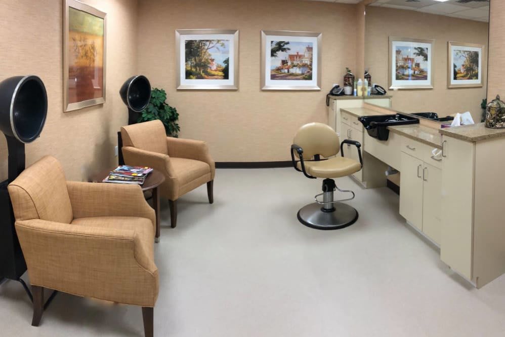 A well-appointed hair salon with comfortable seating and art-adorned walls.