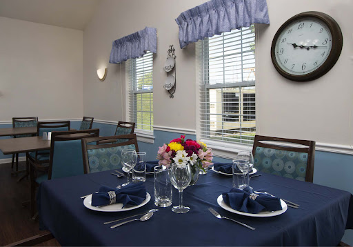 A beautifully set dining table with blue accents, featuring fresh flowers and an inviting atmosphere.