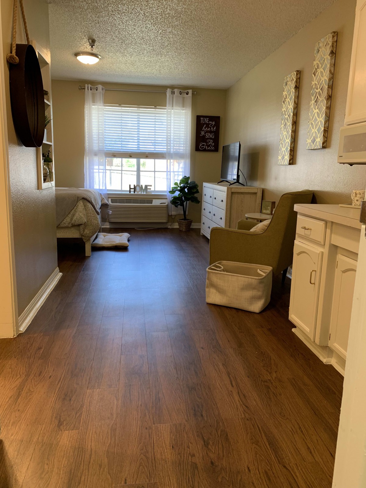 Cozy living room with hardwood floors and a large window.