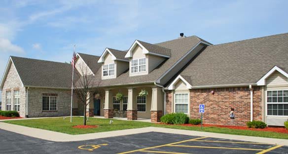 A suburban residential building with a well-maintained lawn and driveway.