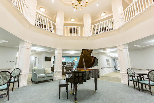 An elegant lobby featuring a grand piano, surrounded by a spacious and stylish design.