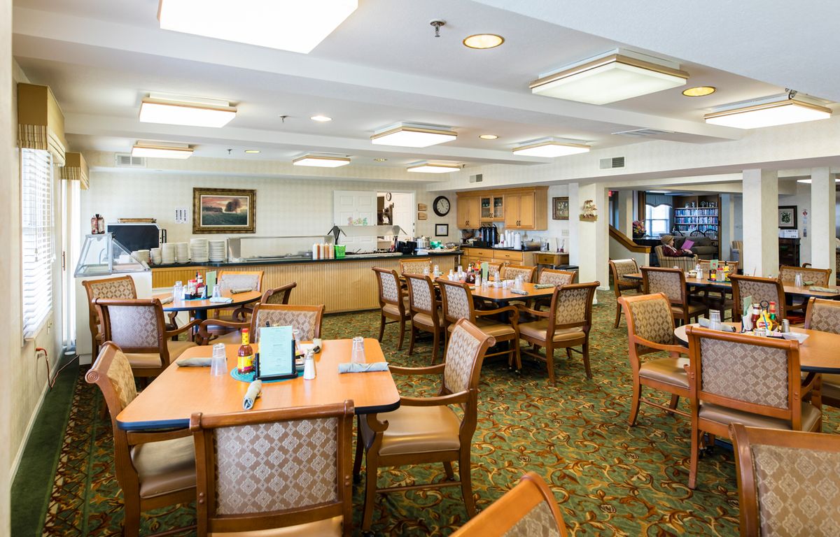 A well-lit dining area with neatly arranged tables and chairs.