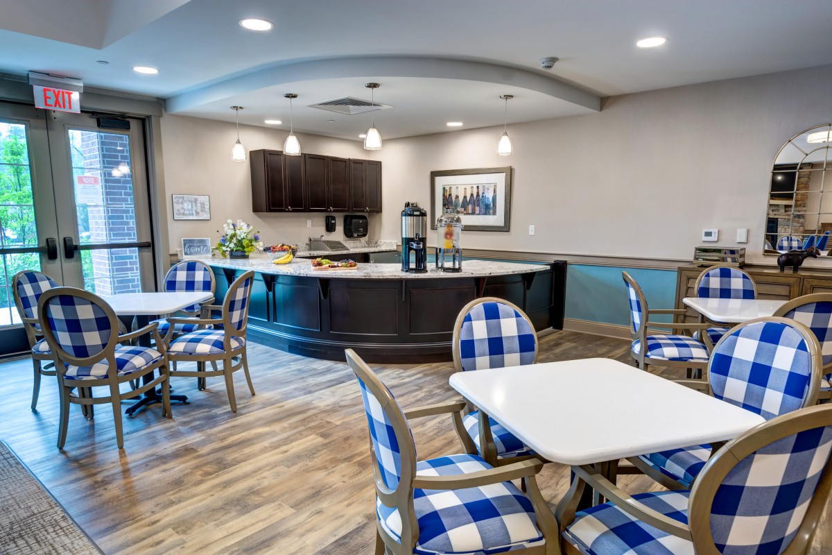 A modern cafeteria with blue checkered chairs and a well-lit dining area.