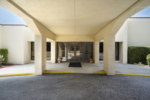 A view of the entrance to a building, showcasing its architectural design with columns and a welcoming lobby area.