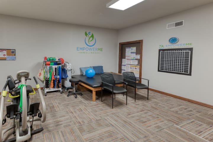 A physical therapy clinic with exercise equipment and seating area.