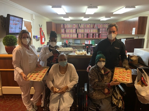 Healthcare staff sharing treats with patients in a hospital setting.